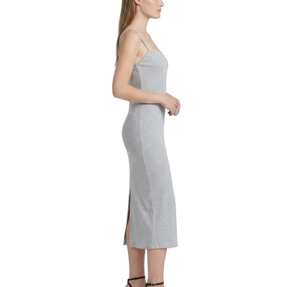Woman wearing a gray Calvin Klein dress with a side slit on a white background