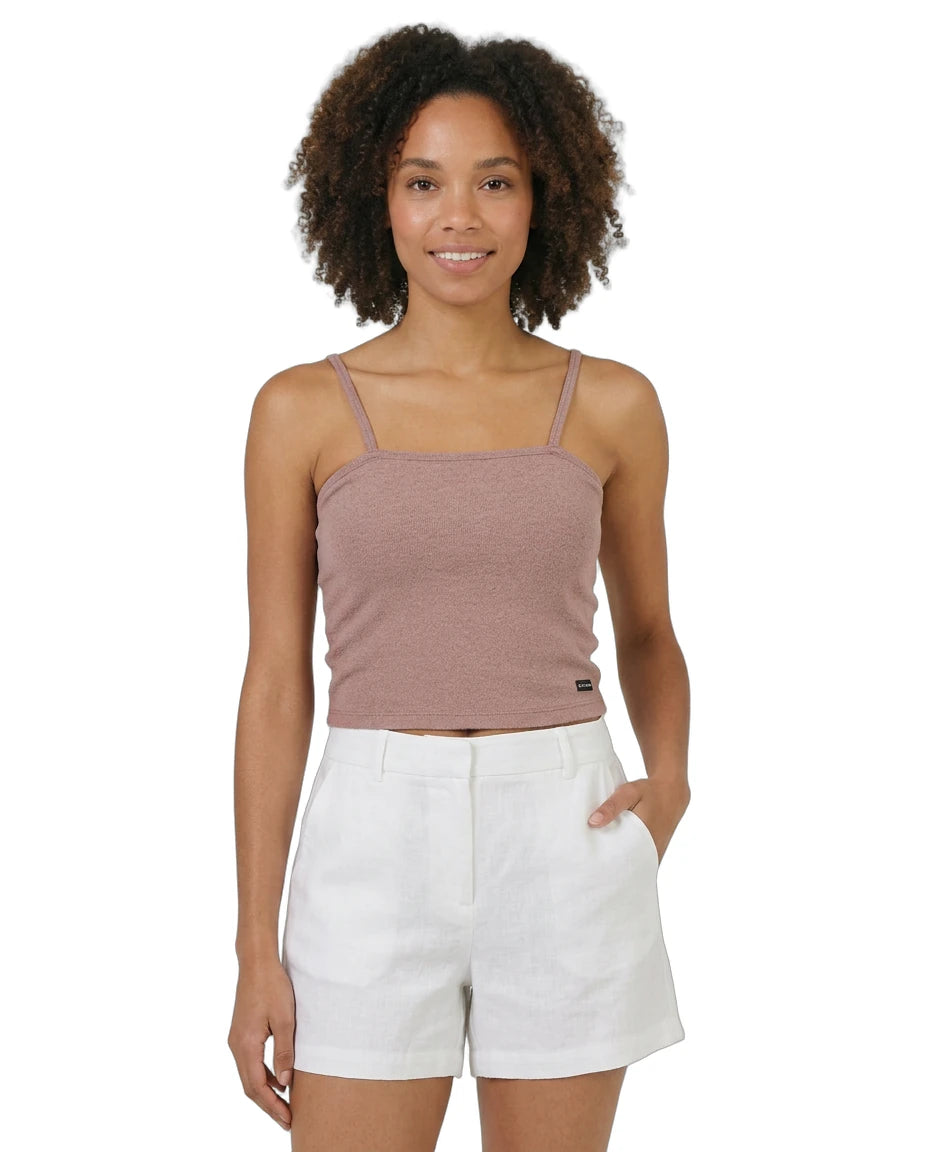 Woman wearing a brown Calvin Klein tank top and white shorts on a white background
