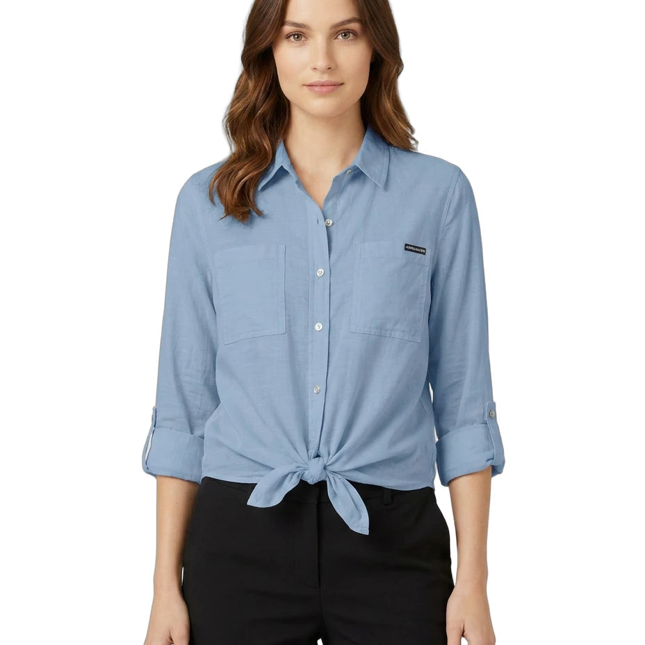 Woman wearing a blue Calvin Klein button-up shirt with a brand logo on a white background