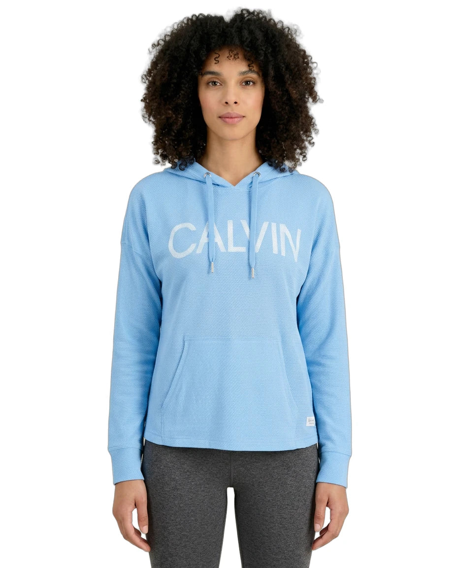 Woman wearing a light blue Calvin Klein hoodie on a white background