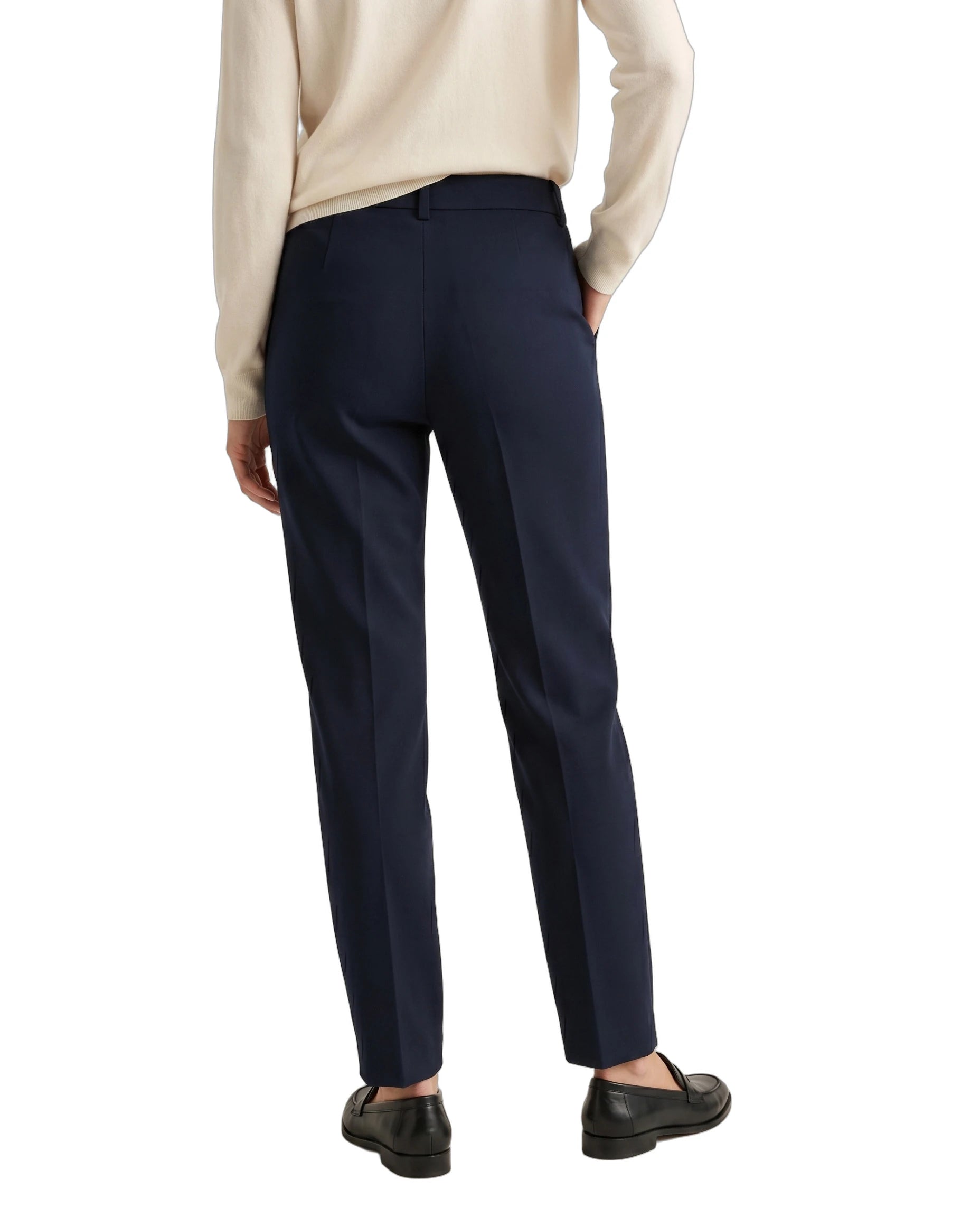 Person wearing navy pants and a beige sweater on a white background