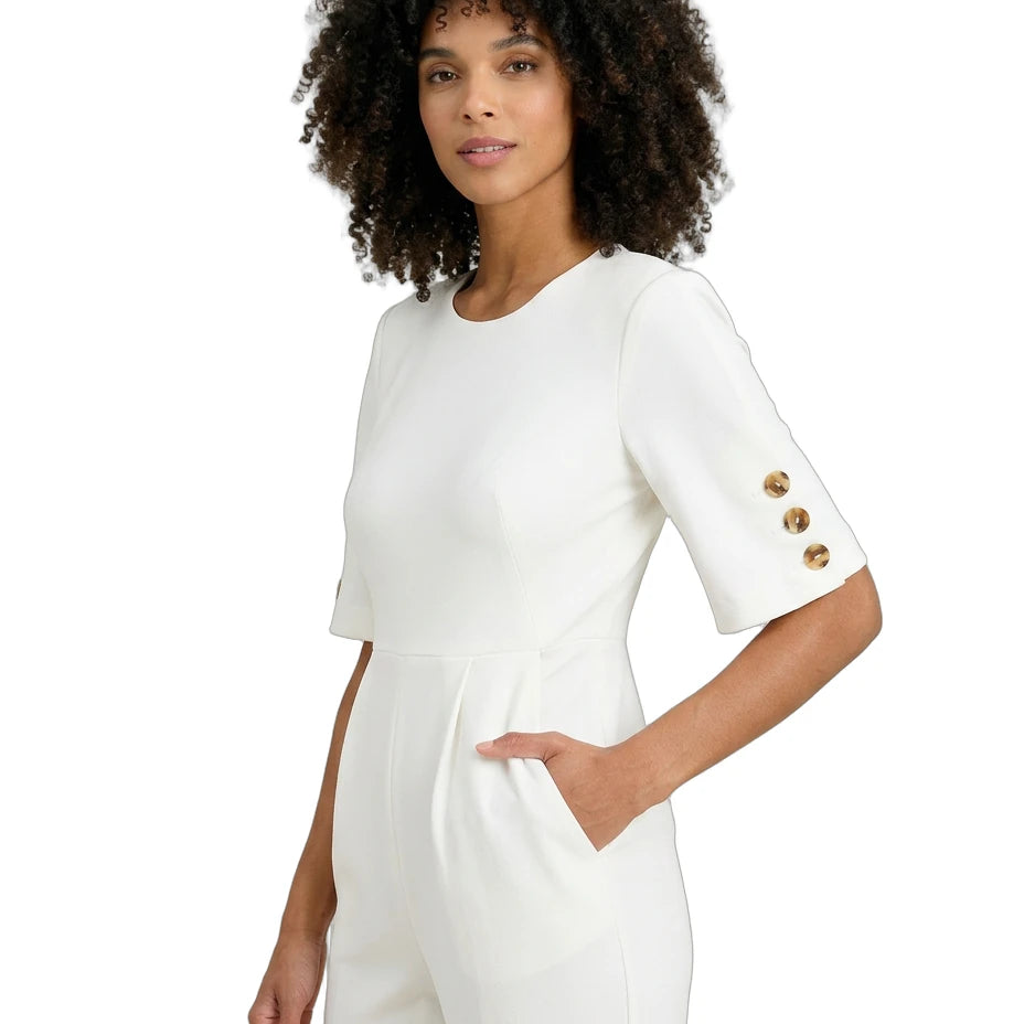 Woman wearing a white outfit with gold buttons on a white background