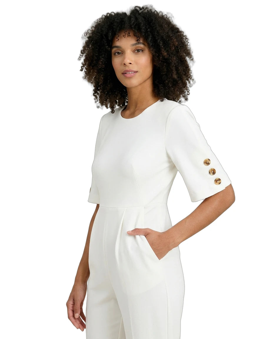 Woman wearing a white outfit with gold buttons on a white background