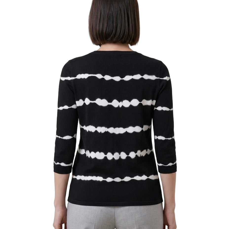 Person wearing a black and white striped sweater on a white background