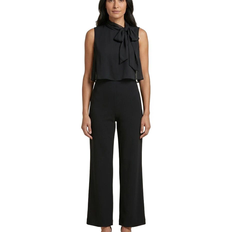 Woman wearing a black sleeveless top with a bow and black pants on a white background