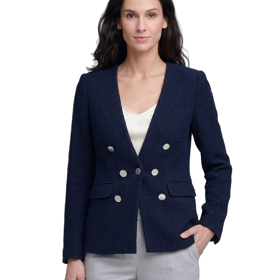 Woman wearing a navy blazer with silver buttons on a white background