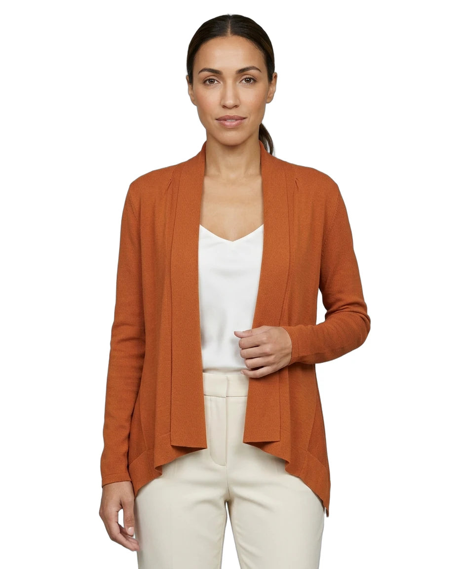 Woman wearing an orange Calvin Klein cardigan over a white top and pants on a white background