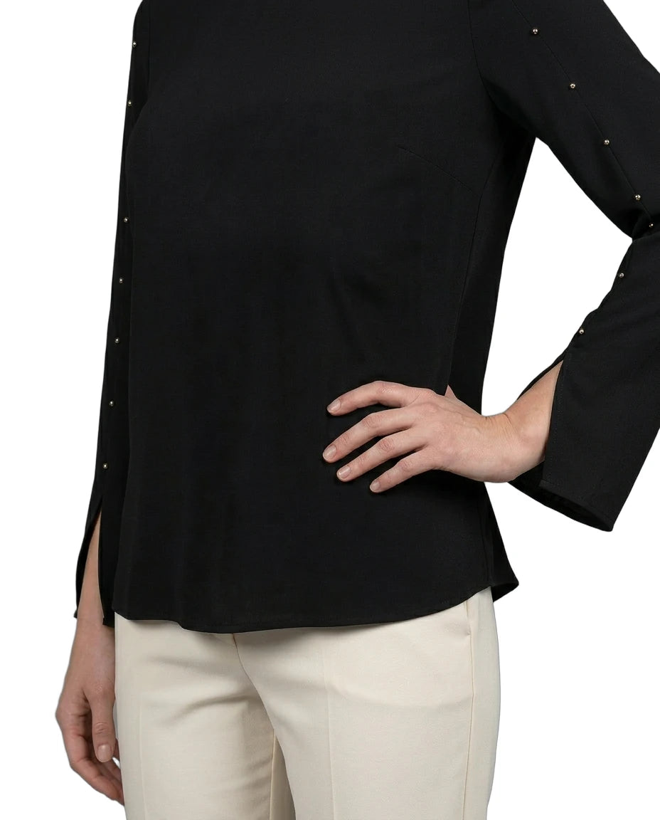 Black long-sleeve top with decorative trim worn by a person on a white background