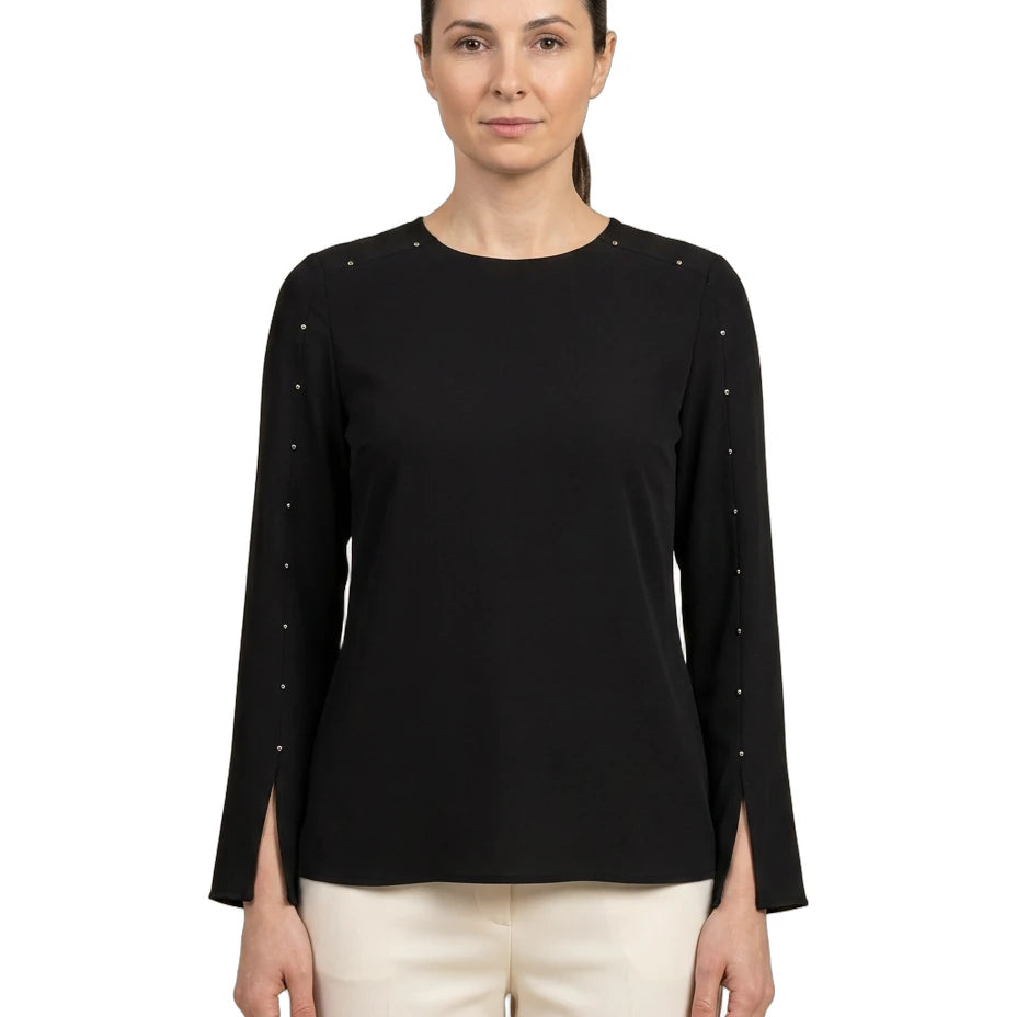 Woman wearing a black long-sleeve top with decorative elements on a white background