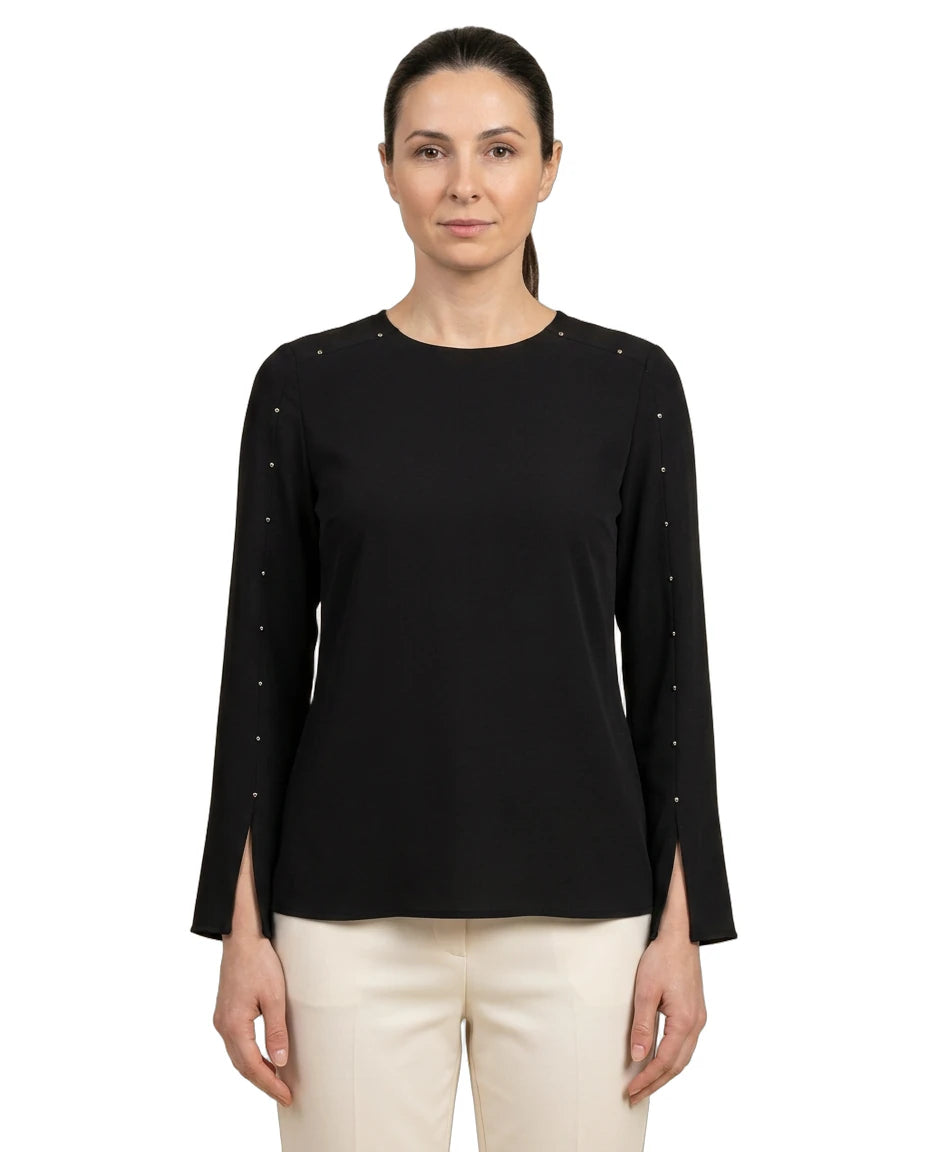 Woman wearing a black long-sleeve top with decorative elements on a white background