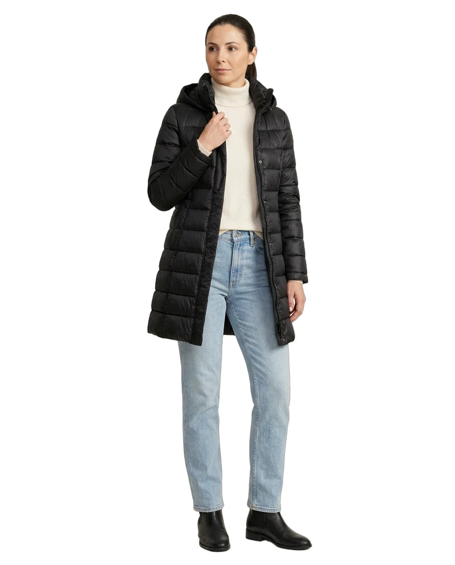 Woman wearing a black Calvin Klein puffer coat on a white background