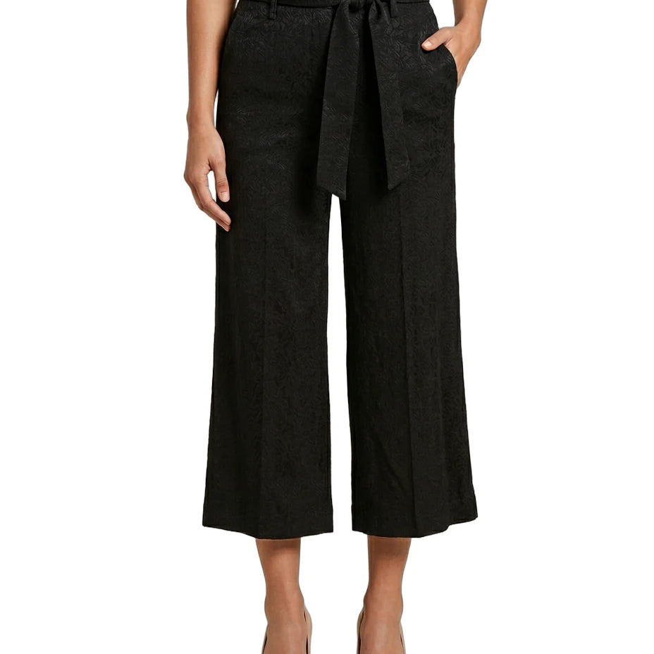 Black Calvin Klein wide-leg pants with a belt worn by a person on a white background