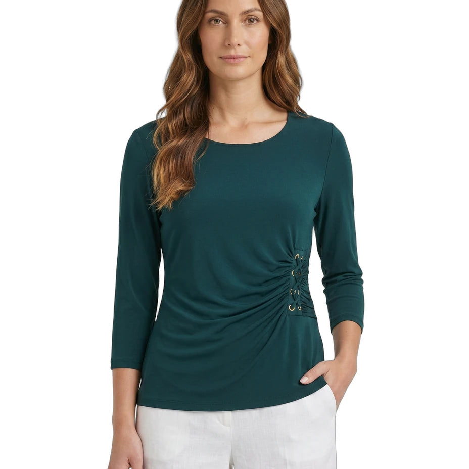 Woman wearing a teal Calvin Klein long-sleeve top with a unique design on a white background