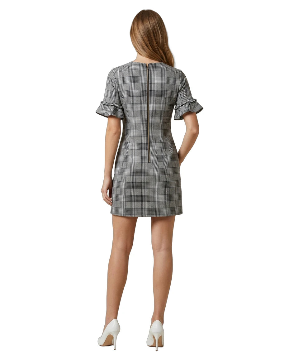 Woman wearing a Calvin Klein gray checkered dress with ruffled sleeves on a white background