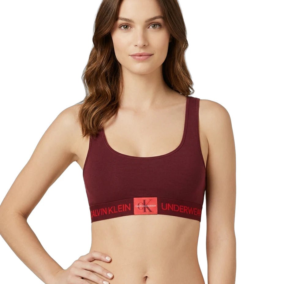 Woman wearing a maroon Calvin Klein bralette on a white background