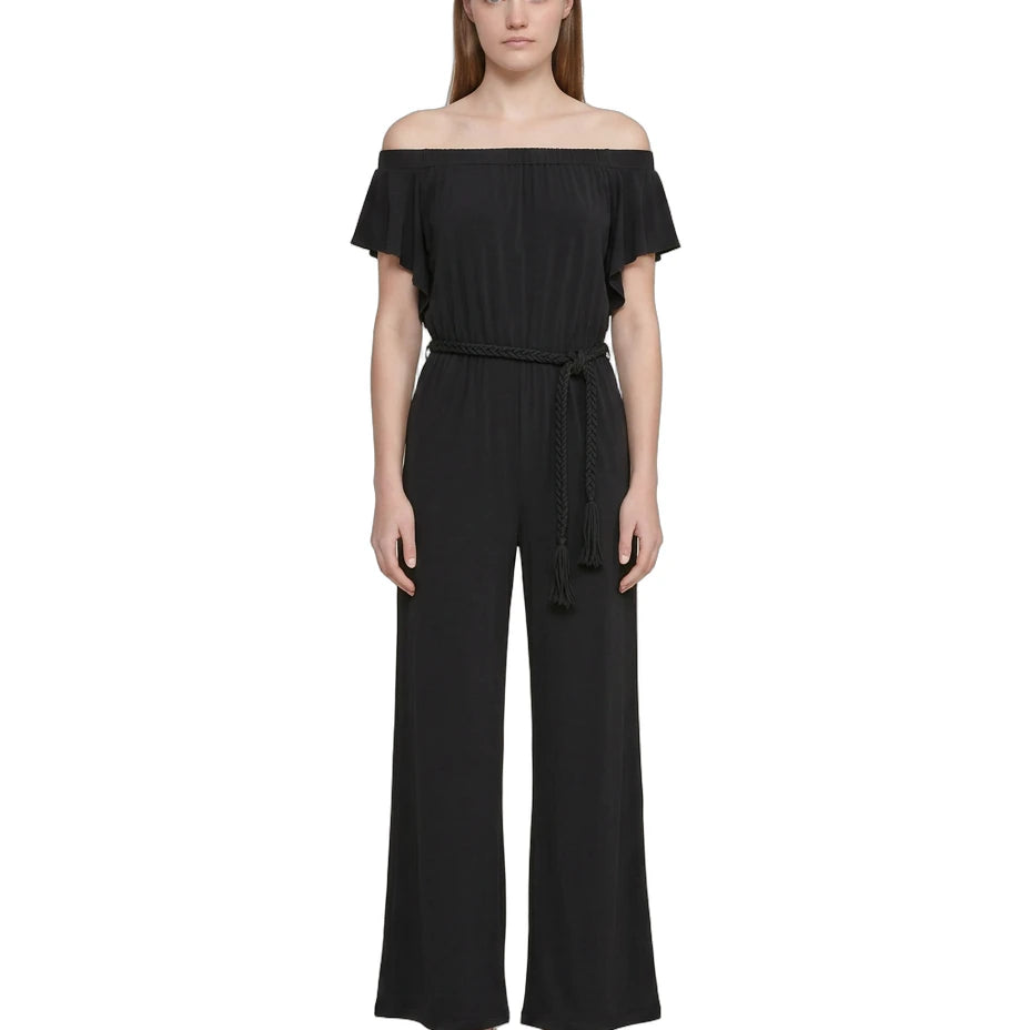 Woman wearing a Calvin Klien black off-shoulder jumpsuit on a white background