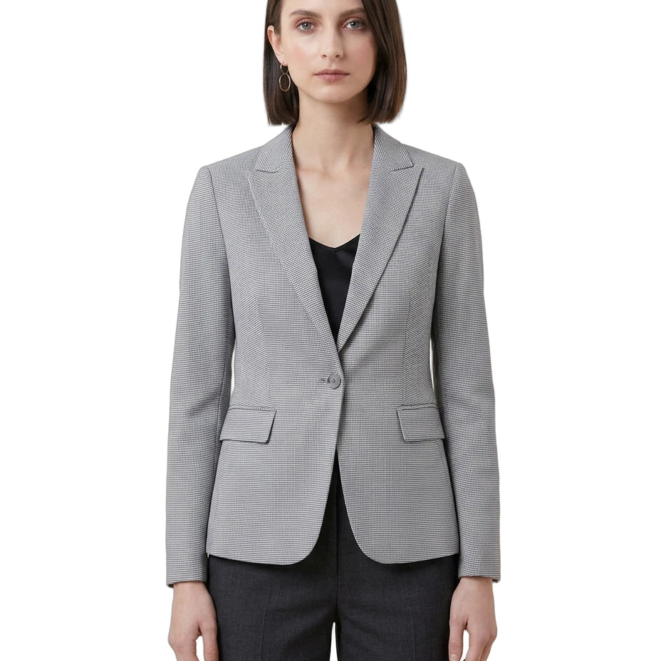 Woman wearing a gray Calvin Klein blazer over a black top on a white background