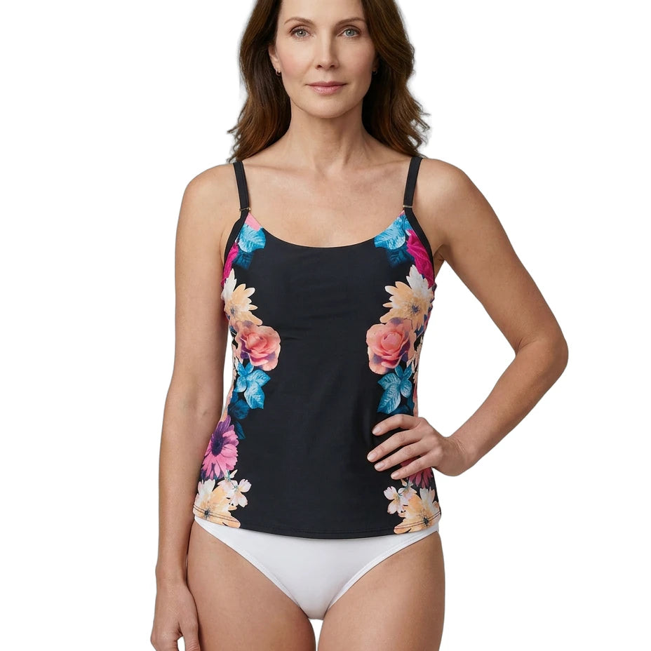 Woman wearing a Calvin Klein black tankini top with colorful floral design and white bottoms on a white background