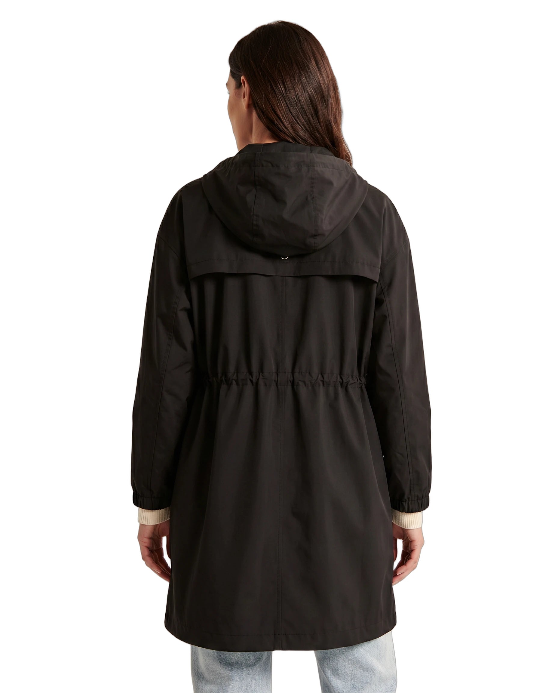 Woman wearing a black Calvin Klein coat viewed from the back, white background