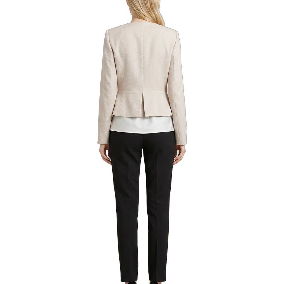 Woman wearing a Calvin Klein beige blazer and black pants on a white background