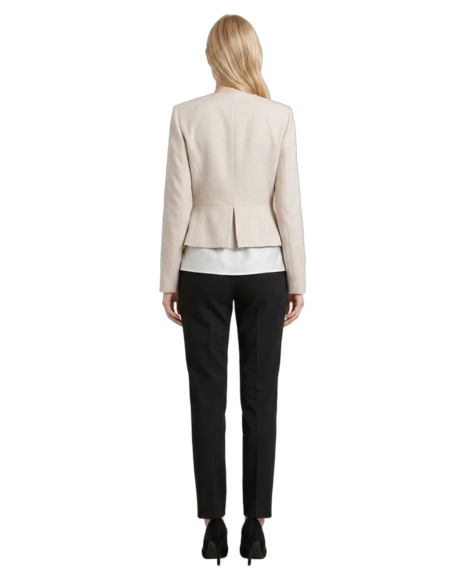 Woman wearing a Calvin Klein beige blazer and black pants on a white background
