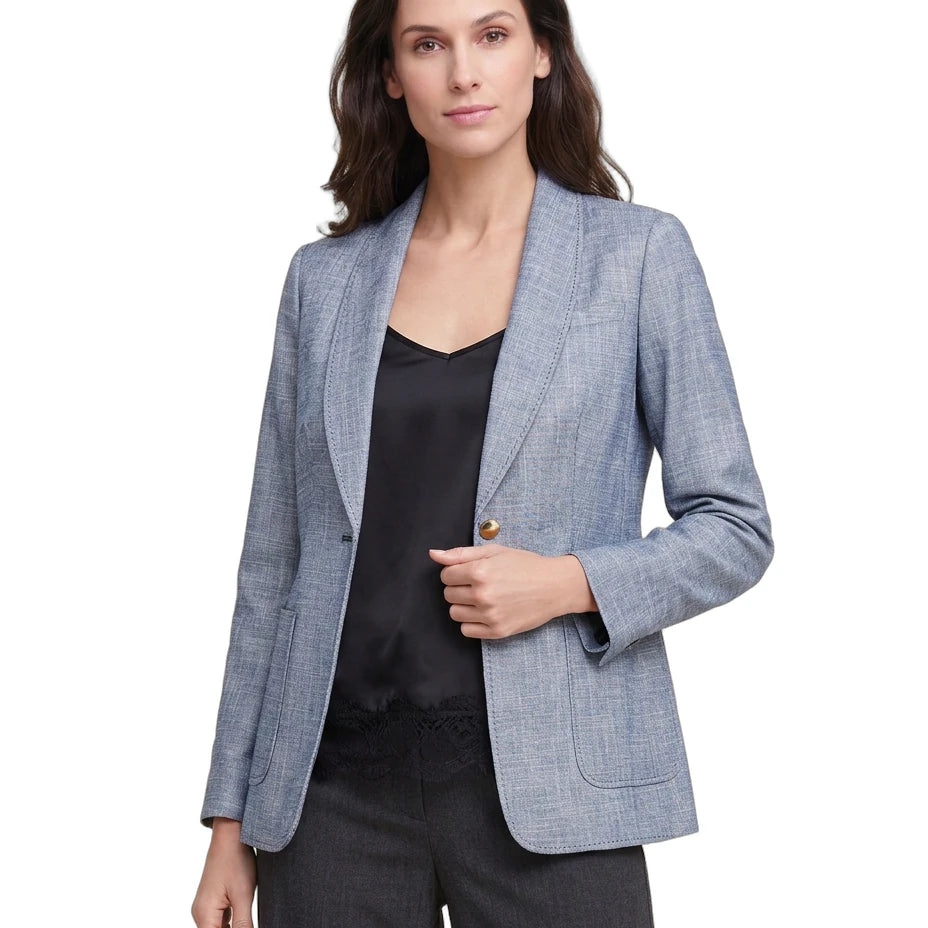 Woman wearing a light blue Calvin Klein blazer over a black top and pants on a white background