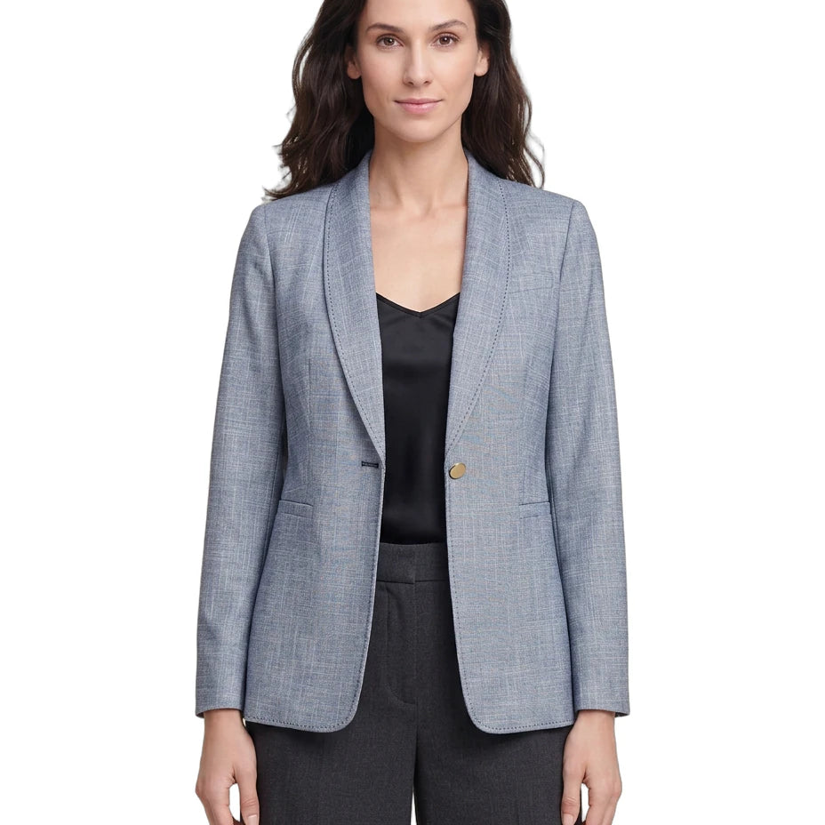 Woman wearing a light blue Calvin Klein checkered blazer over a black top on a white background