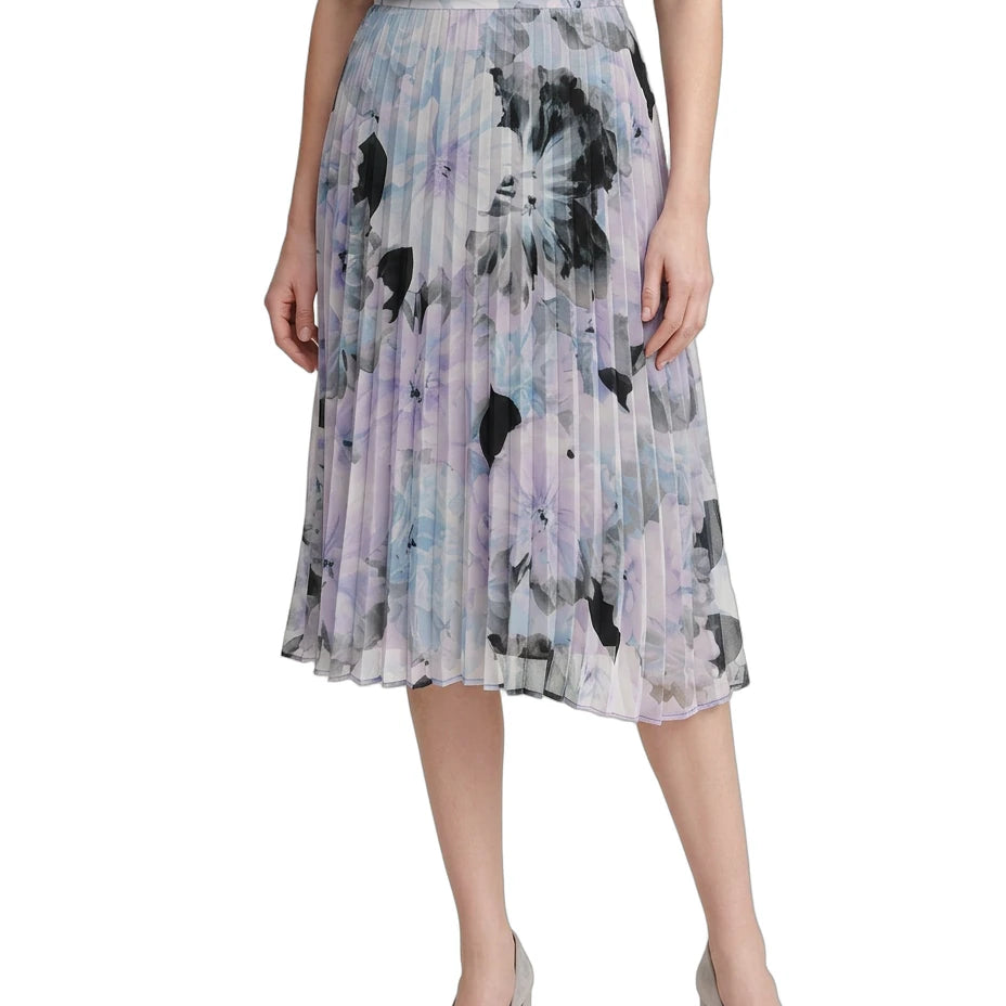 Woman wearing a Calvin Klien pleated skirt with abstract floral pattern on a white background
