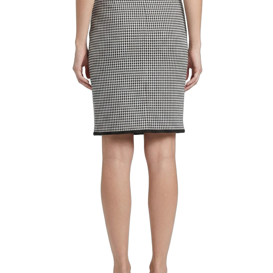 Person wearing a Calvin Klein houndstooth patterned skirt on a white background