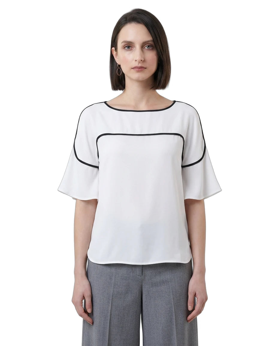 Woman wearing a white Calvin Klein blouse with black accents on a white background
