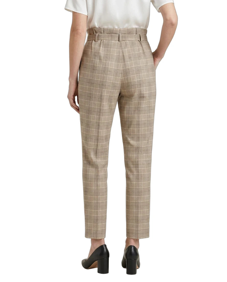 Person wearing Calvin Klein beige checkered pants on a white background