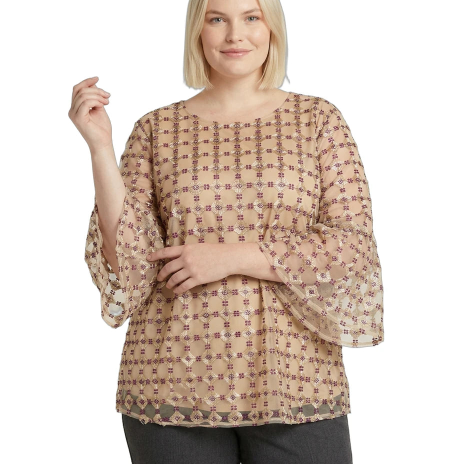Woman wearing a beige patterned Calvin Klein blouse on a white background