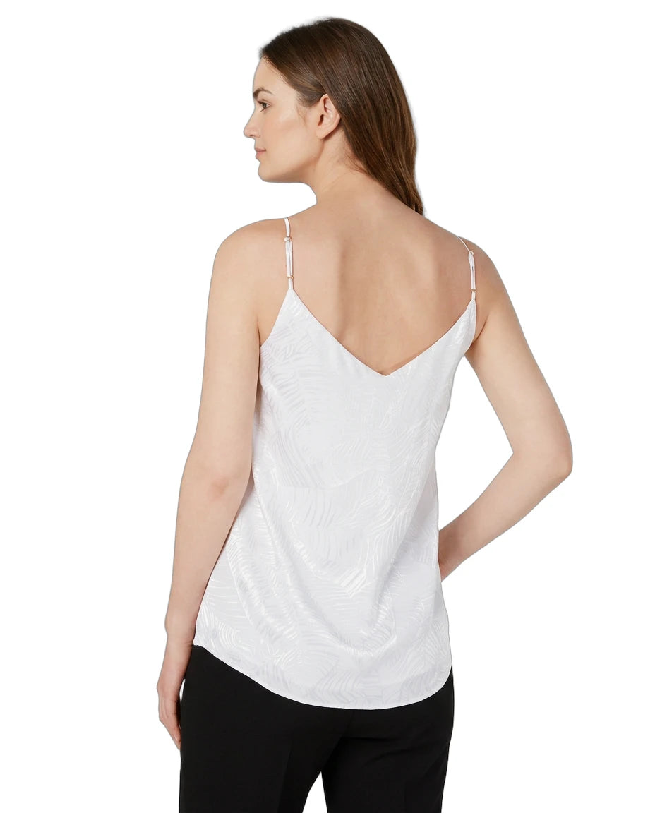 Woman wearing a white Calin Klein spaghetti strap top on a white background