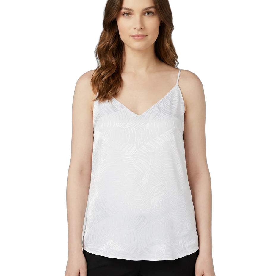 Woman wearing a white Calin Klein sleeveless top on a white background