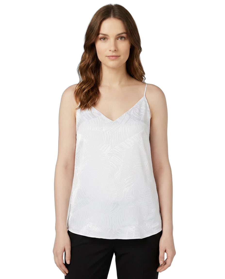 Woman wearing a white Calin Klein sleeveless top on a white background