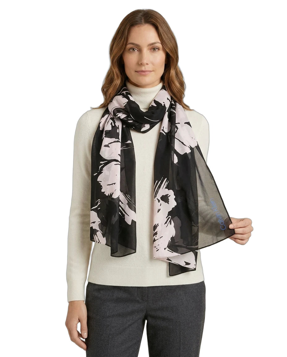 Woman wearing a black and white Calvin Klein floral scarf on a white background