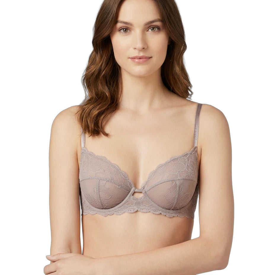 Woman wearing a beige Calvin Klein bra on a white background
