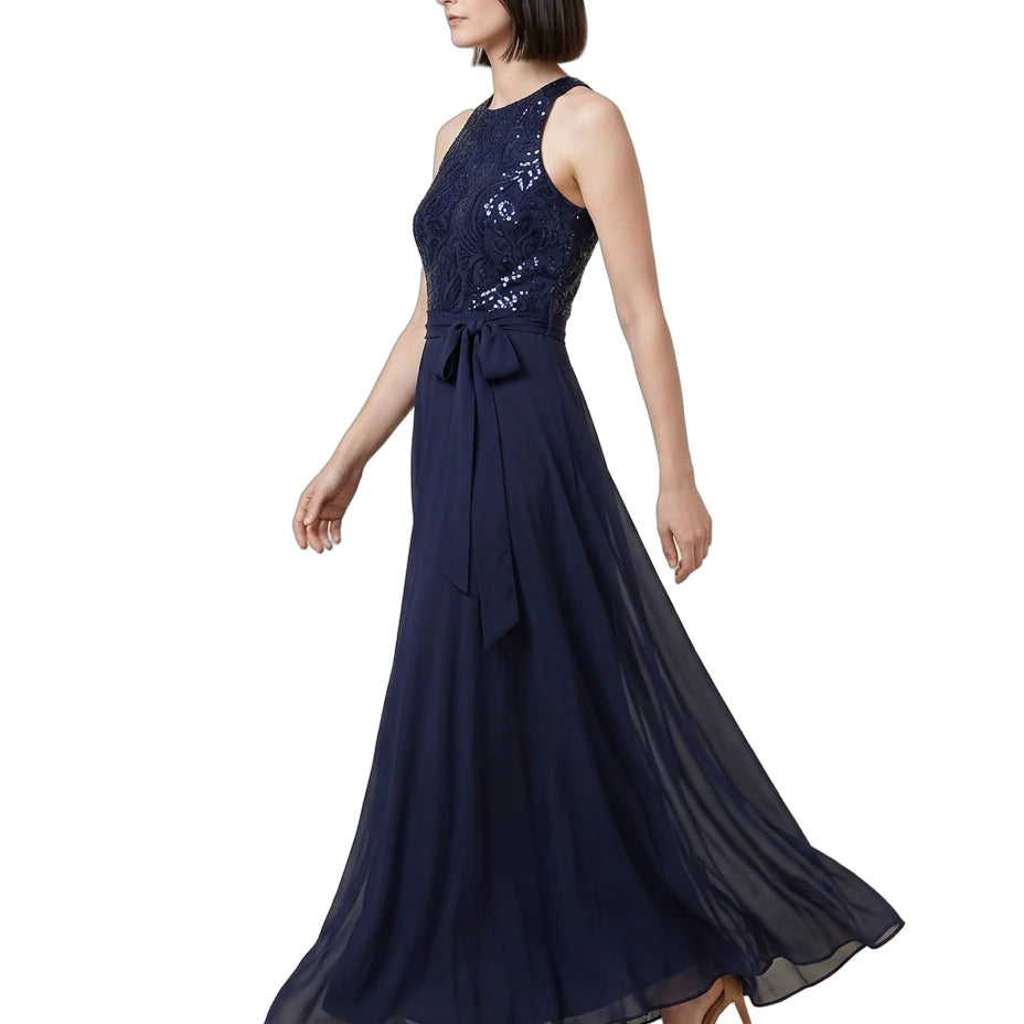 Woman wearing a navy blue Calvin Klein evening gown with sequin detailing on a white background