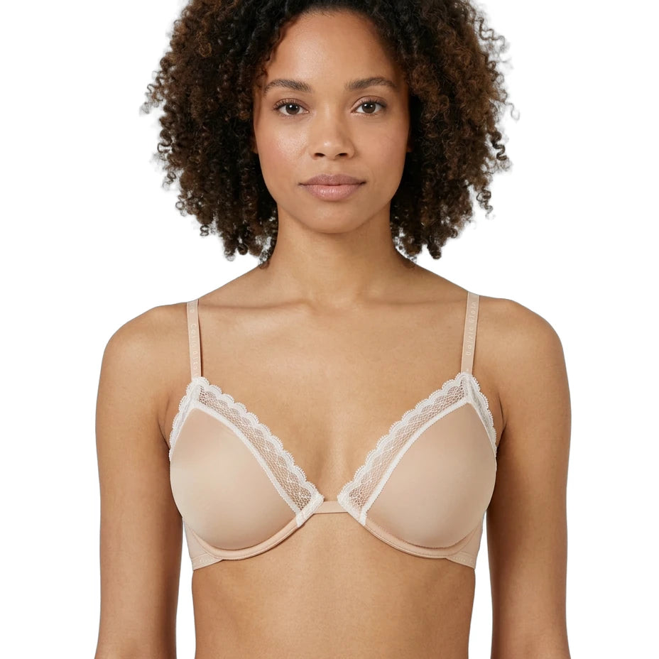 Woman wearing a beige Calvin Klein bra with lace trim on a white background