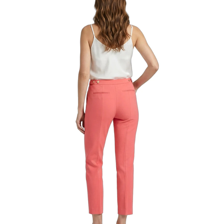 Woman wearing coral Calvin Klein pants and a white top on a white background