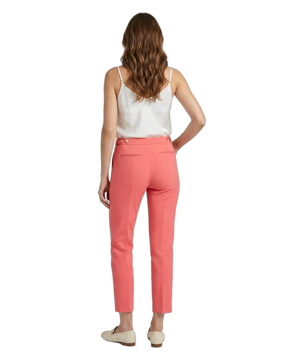 Woman wearing coral Calvin Klein pants and a white top on a white background