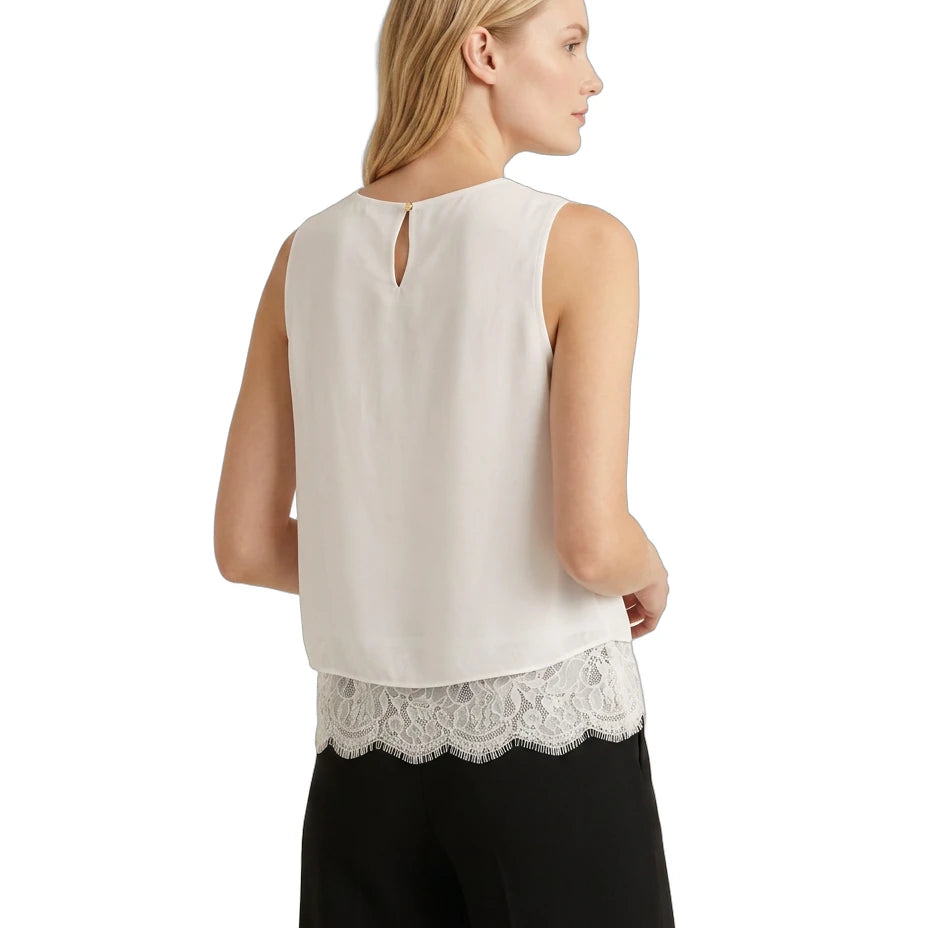 Woman wearing a sleeveless Calvin Klein top with lace trim on a white background