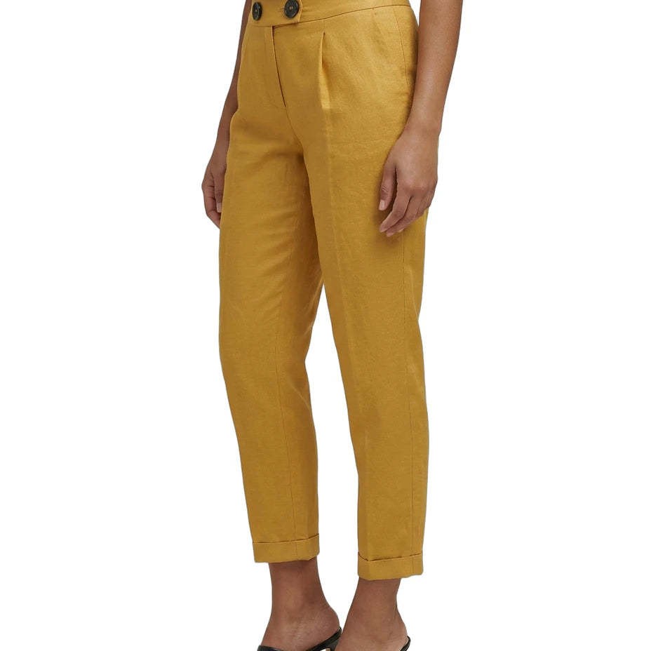 Mustard yellow Calvin Klein pants worn by a person on a white background
