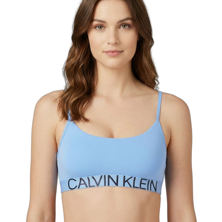 Woman wearing a blue Calvin Klein bralette on a white background