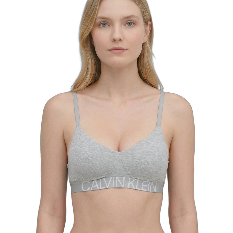 Woman wearing a Calvin Klein bralette on a white background