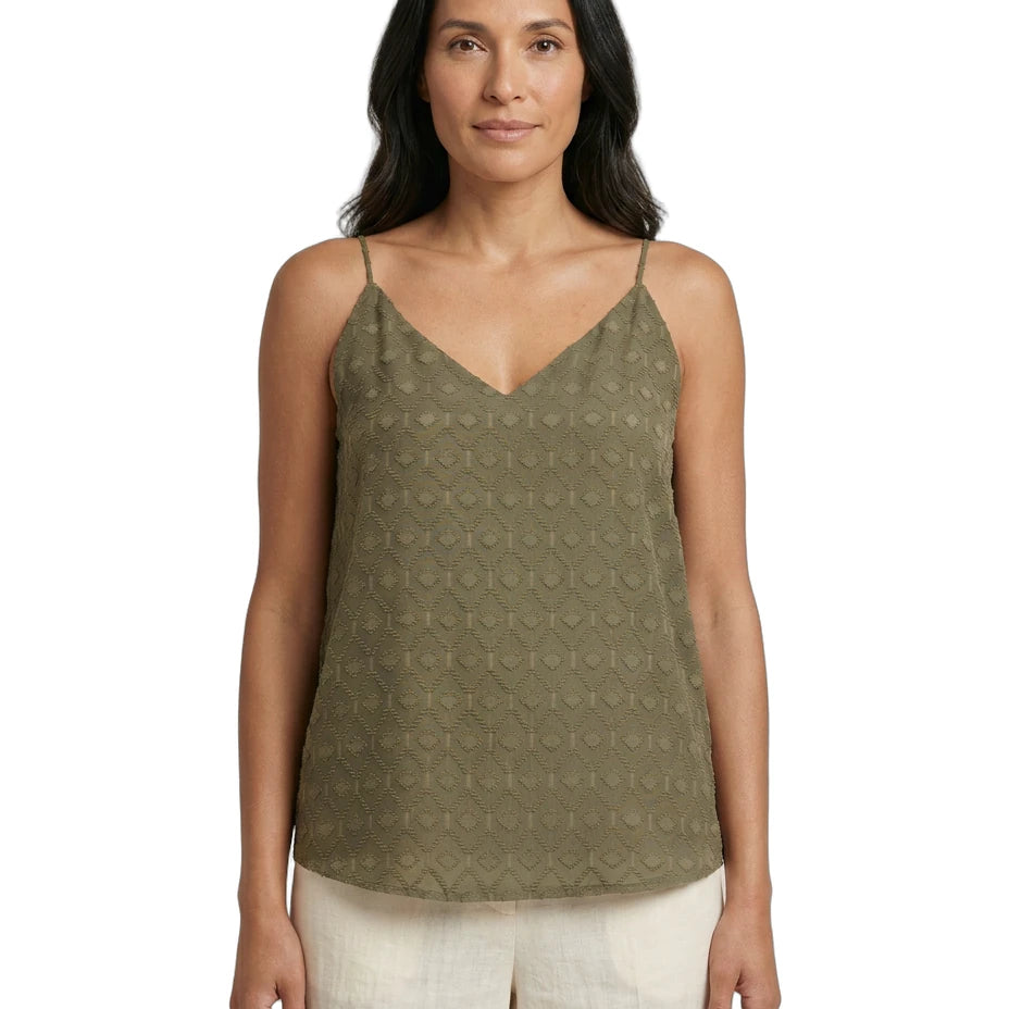 Woman wearing a green patterned Calvin Klein tank top on a white background