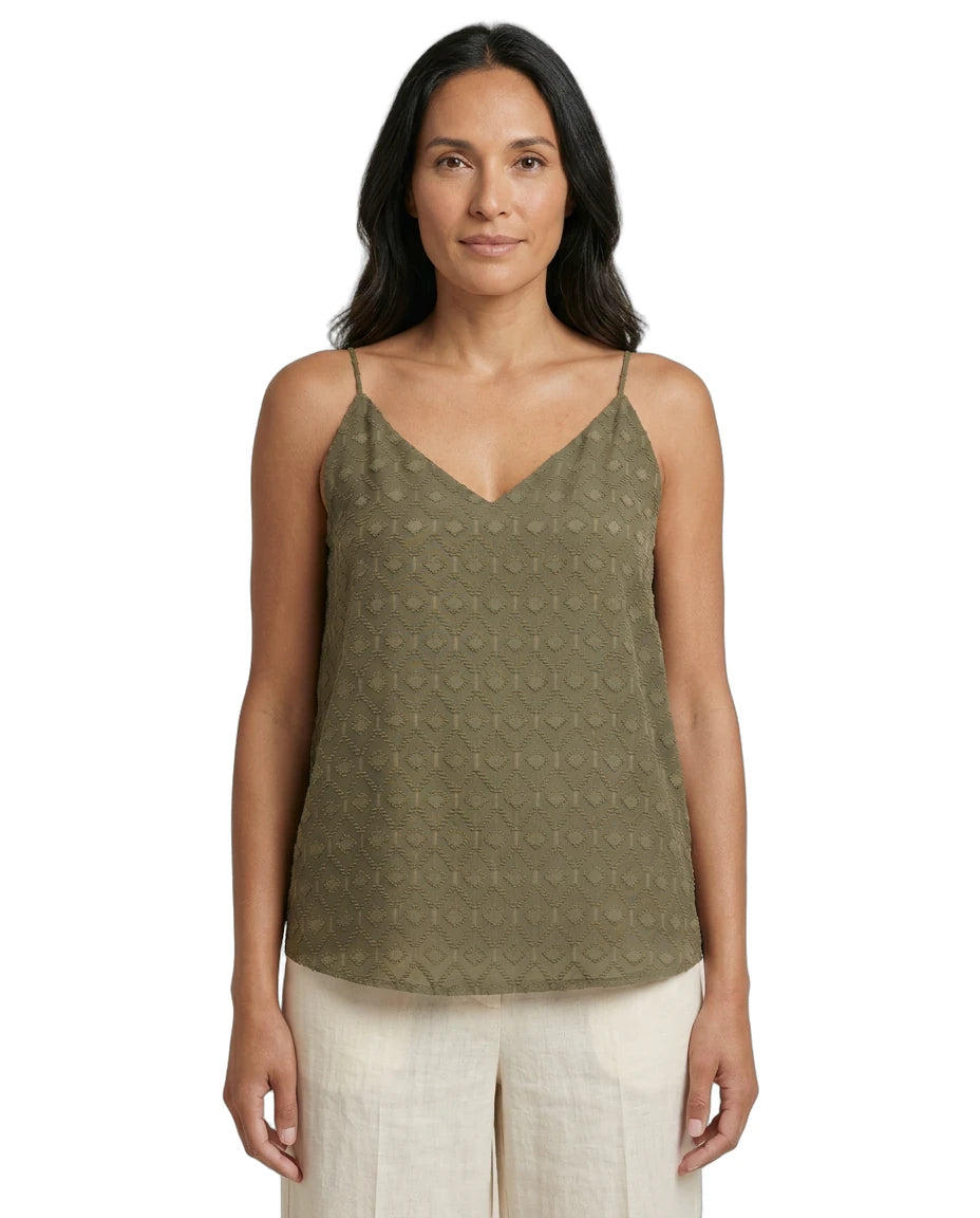Woman wearing a green patterned Calvin Klein tank top on a white background