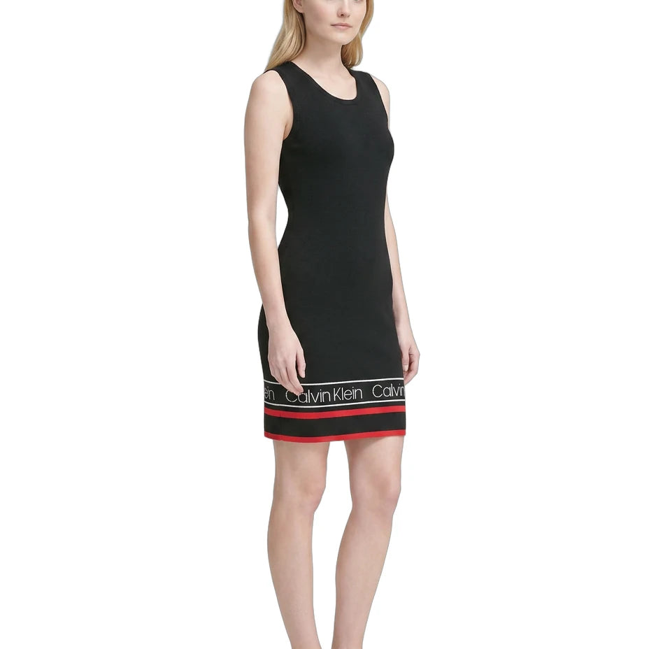 Woman wearing a black Calvin Klein dress with a white background
