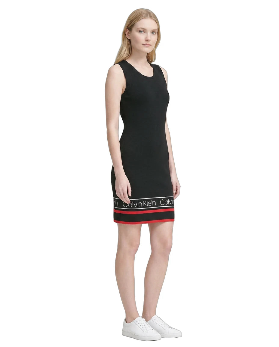 Woman wearing a black Calvin Klein dress with a white background