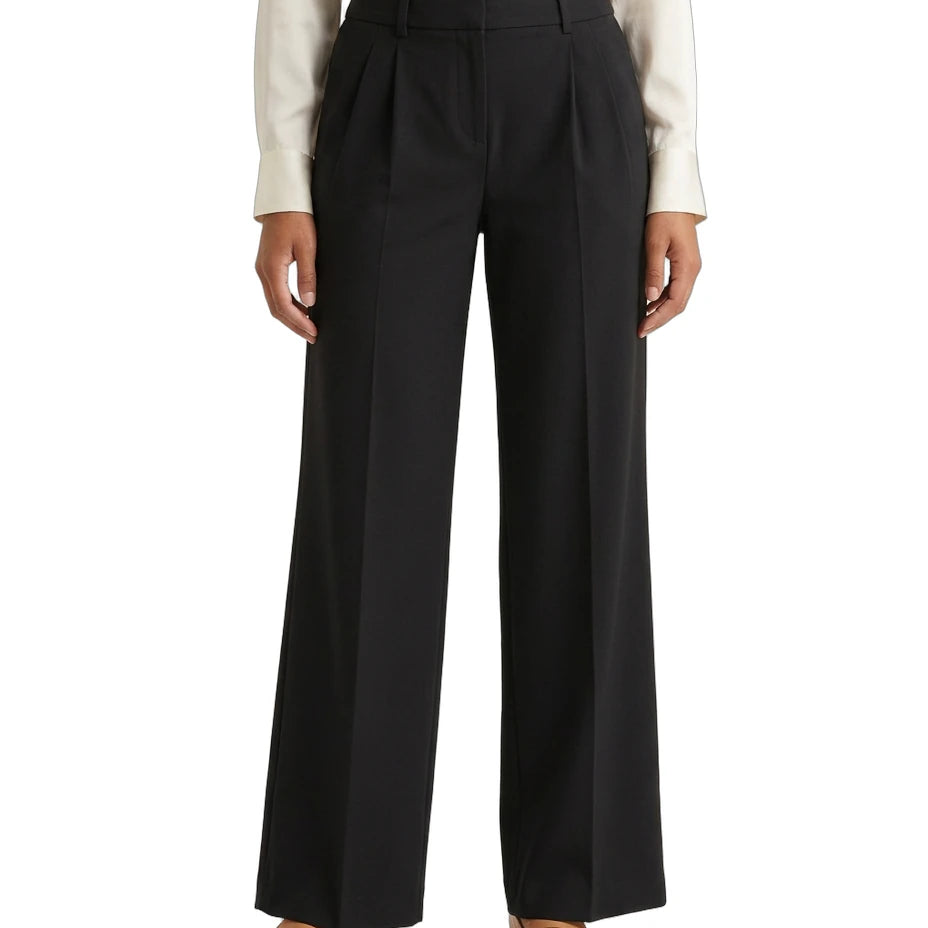 Person wearing a white shirt and Calvin Klein black wide-leg pants on a white background
